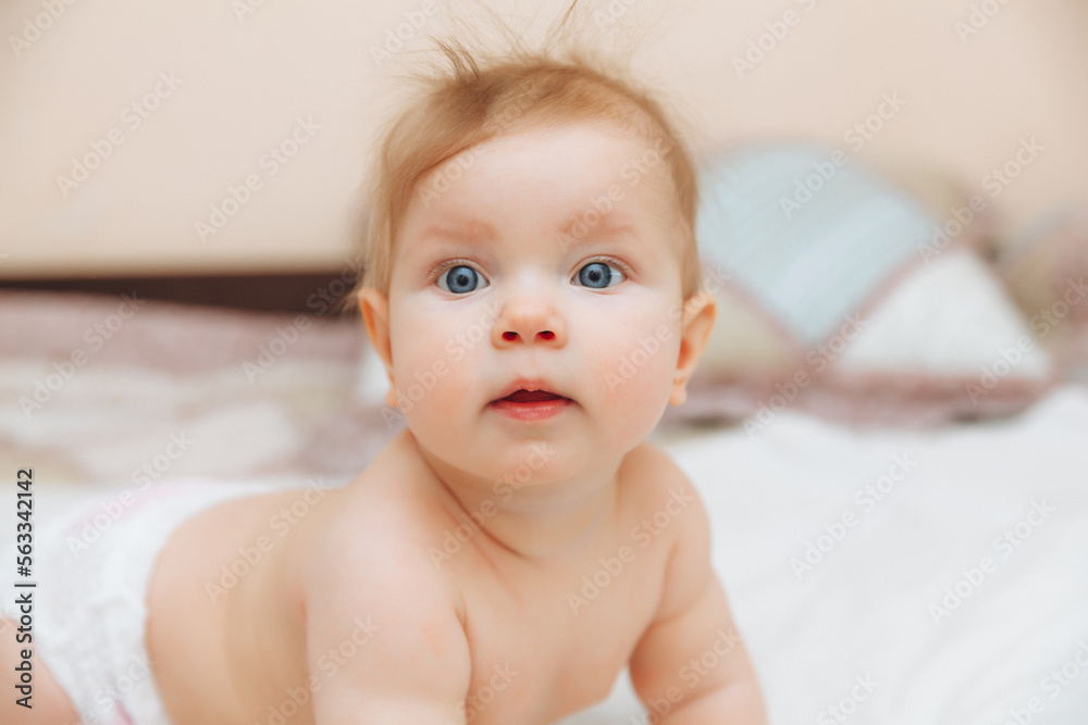 a funny baby crawling in the nursery at home. the baby is 6 months old learning to crawl a funny baby crawling in the nursery at home. the baby is 6 months old learning to crawl