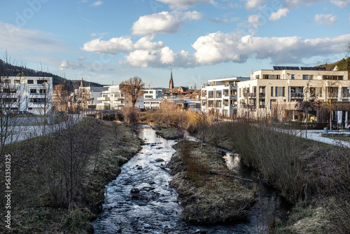 Moderne Wohnsiedlung an Fluß im Kontrast zu mittelalterlicher Kirche