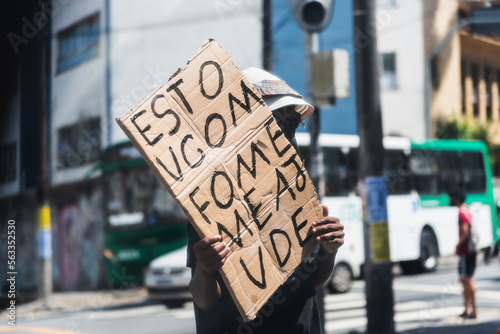 Beggar asking for money and food with a sign in traffic in Salvador, Bahia. photo