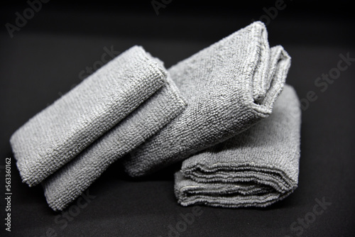 Three gray towels on a black background. Terry cloths for wiping furniture. Towels on a black background.