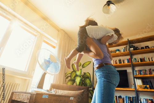 Girl cools off with mom in living room playing