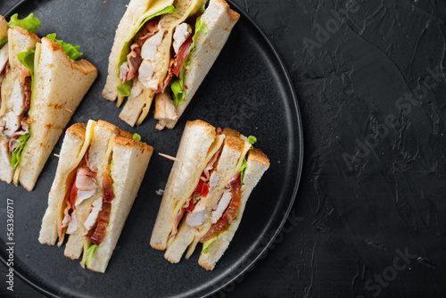 Deli meat sandwich with chicken, on black background, top view with copy space for text