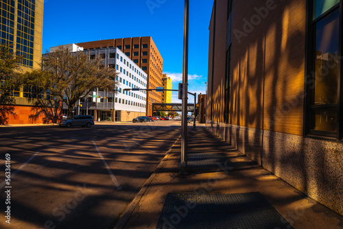 City building facade illuminated by vibrant sunbeams and colorful reflections on empty asphalt street in Abilene, Texas, USA photo