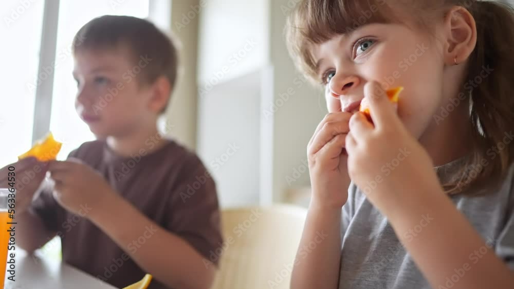 children eat oranges. happy family a kid dream concept. drinking fresh juices. morning breakfast brother and sister eat oranges in the kitchen. fruits orange fun juice healthy eating children eat oranges. happy family a kid dream concept. drinking fresh juices. morning breakfast brother and sister eat oranges in the kitchen. fruits orange fun juice healthy eating