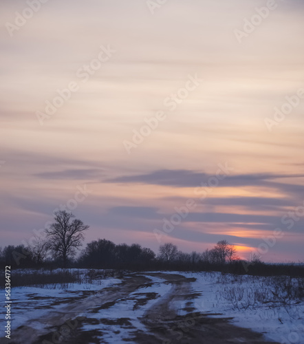 Winter landscape in the evening in the fields of Slobozhanshchina, clouds and the setting sun on the horizon © Denis