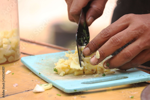 close up view of mens chef knife cutting the potato. Healthy eating and lifestyle