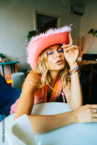 Portrait of attractive caucasian woman fashion model with blonde hair in pink cowboys hat , posing 