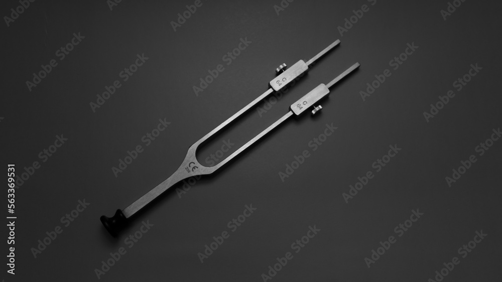 tuning fork C 128 on a grey background with gradation tuning fork C 128 on a grey background with gradation