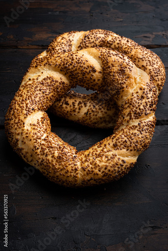 Turkish bagel Simit with sesame , on old dark wooden table background, top view flat lay, with copy space for text