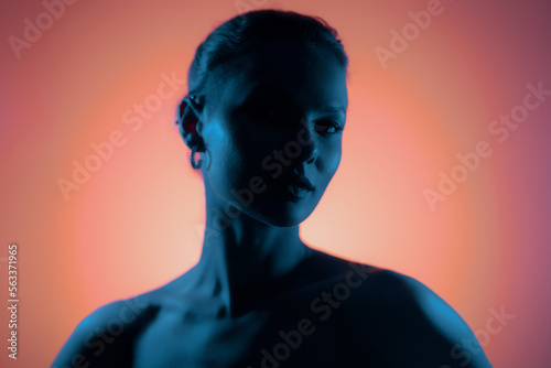 Dark woman profile portrait on pink gradient background with soft blue light play on skin and copy space. Lights play.