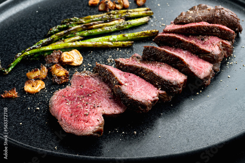 Grilled fillet beef steaks, with onion and asparagus, on plate Fototapeta