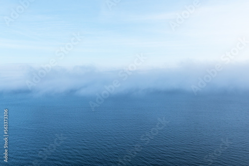 Fog lies on the border of sea water and sky
