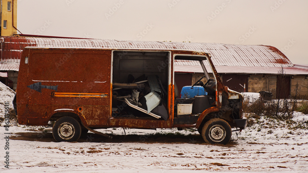 Old rusty minibus in a junkyard.