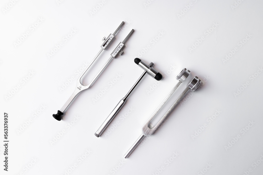 tuning fork C 128 on a white background with gradation and neurological hammer tuning fork C 128 on a white background with gradation and neurological hammer