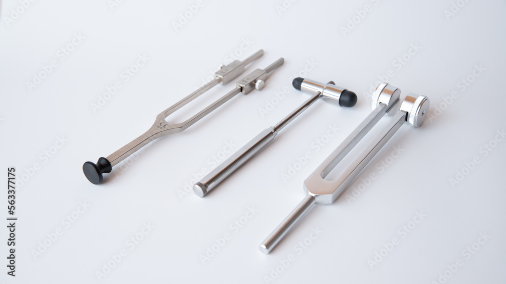 tuning fork C 128 on a white background with gradation and neurological hammer, medical instruments, equipment tuning fork C 128 on a white background with gradation and neurological hammer, medical instruments, equipment