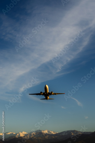 The plane takes off, blue sky on the background, mountains