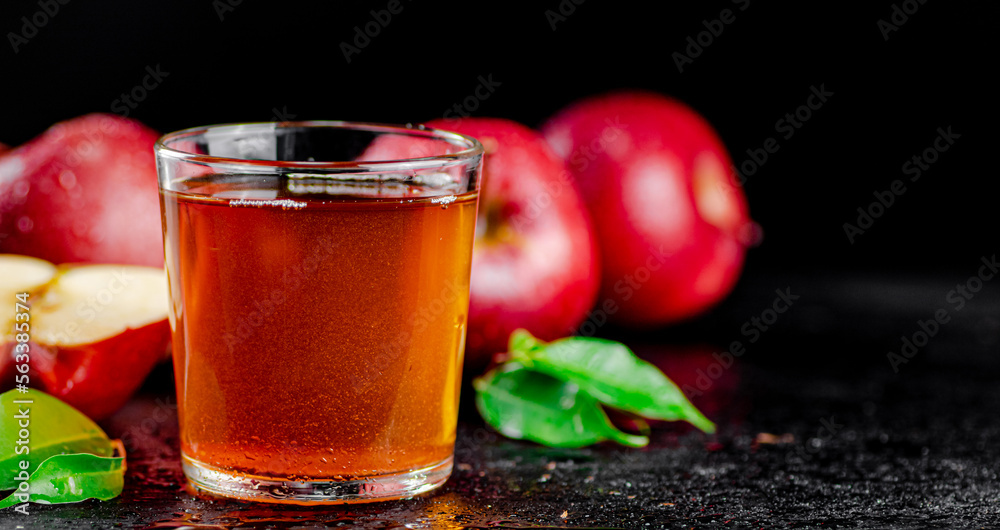 A full glass of apple juice with leaves. A full glass of apple juice with leaves.