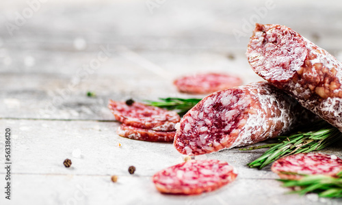 Pieces of salami sausage with sprigs of rosemary. 