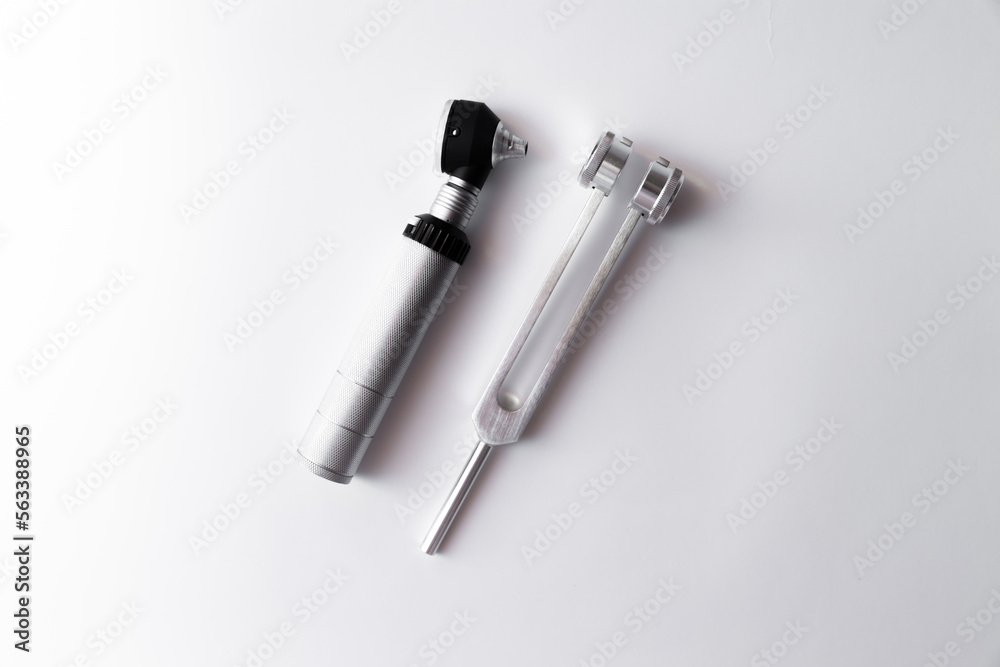 tuning fork C 128 on a white background with gradation and otorhinoscope tuning fork C 128 on a white background with gradation and otorhinoscope