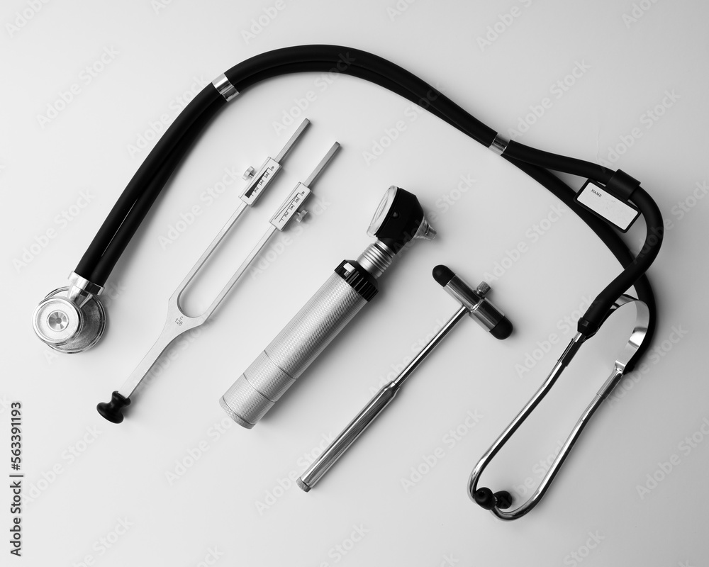 tuning fork C 128 on a white background with gradation, otorhinoscope, neurological hammer and stethoscope tuning fork C 128 on a white background with gradation, otorhinoscope, neurological hammer and stethoscope