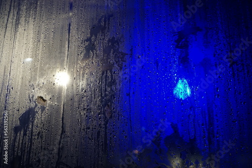 Abstraktes Motiv mit feuchter beschlagener grau-blaue Plastikfolienwand mit Wasser- und Lichtmuster bei Nacht im Winter © Anette