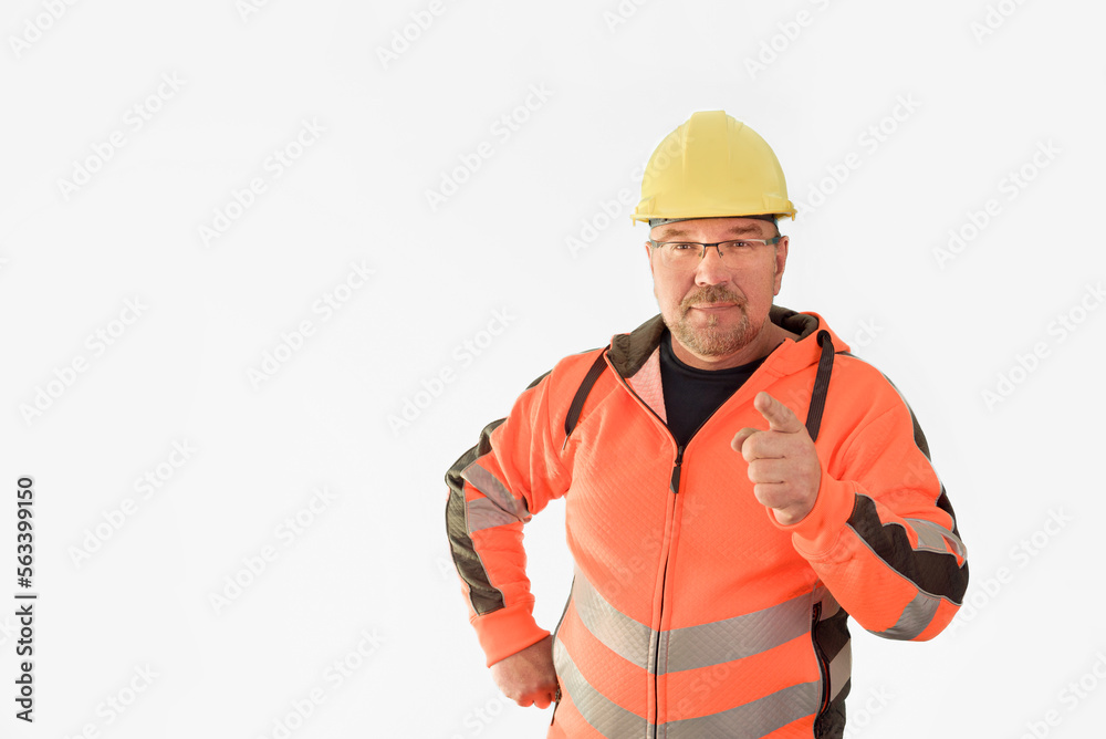 Portrait of a builder mechanic giving advice to the camera. A middle-aged male builder with a beard in a hard hat and uniform, isolated on a white background. Copy space for text on the left