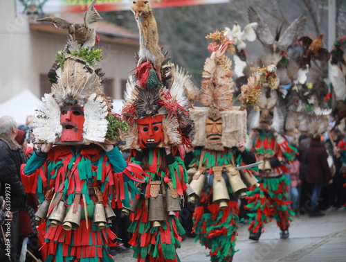 Breznik, Bulgaria - January 21, 2023: Unidentified people with traditional Kukeri costume are seen at the Festival of the Masquerade Games Surova in Breznik, Bulgaria photo