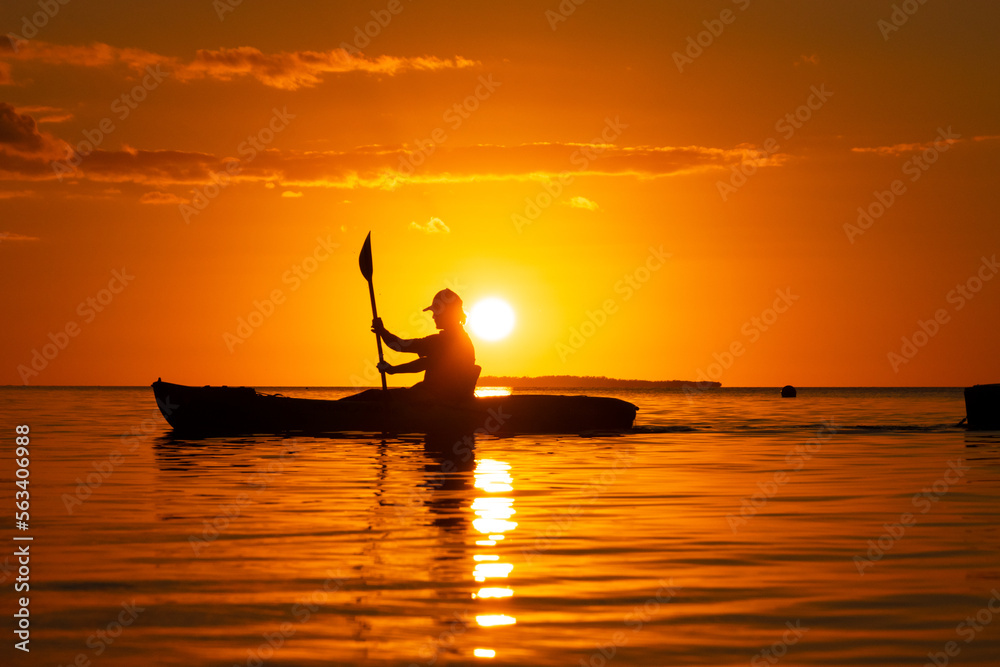 silhouette of a person in a boat at sunset