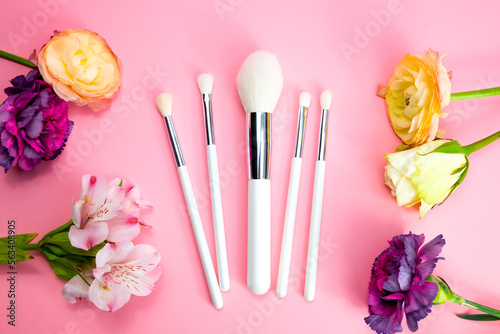 White make up brushes on a pink background. Set makeup brushes on pink color background. Top view point, flat lay. Makeup brushes of different sizes on a pink background. Make up brush sets arranged 