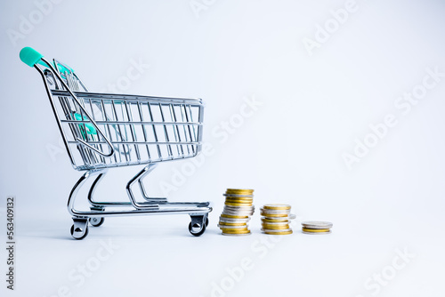 The coins rows and empty shopping basket. Concept of the economic crisis. Inflation. Food shortages, food crisis, famine problems. Letter blocks with word inflation 2023.