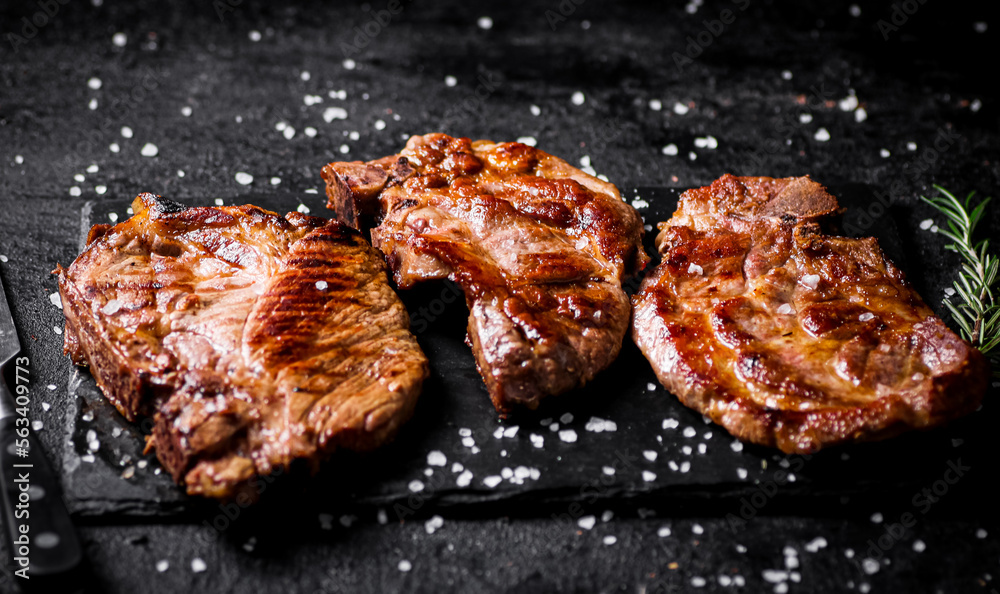 Grilled pork steak with a sprig of rosemary. Grilled pork steak with a sprig of rosemary.