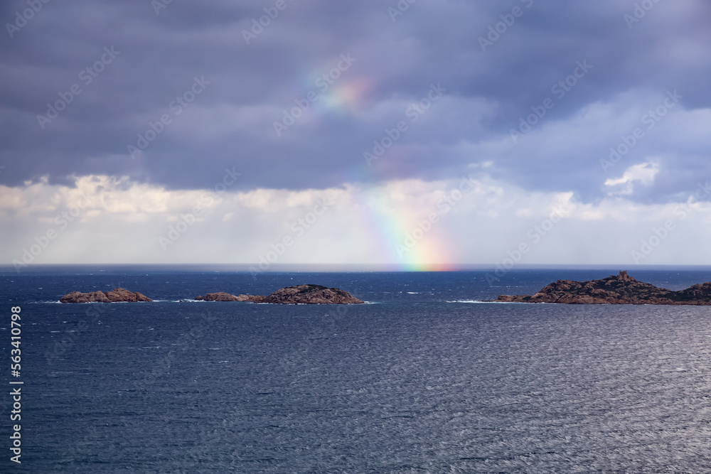 Rocky Coast and Sea with colorful Rainbow in Sky. Sardinia, Italy. Nature Background.