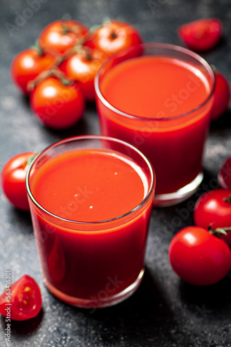 Fresh tomato juice. On a black background.