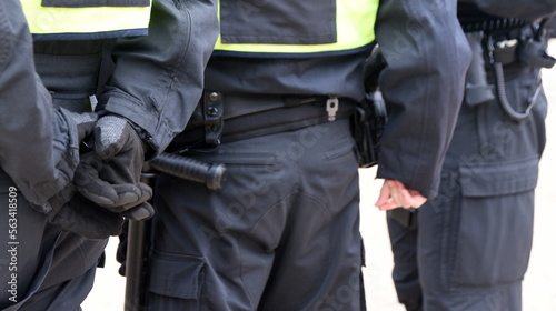 Polizisten in schwarzer Uniform und voller Ausrüstung im Einsatz photo
