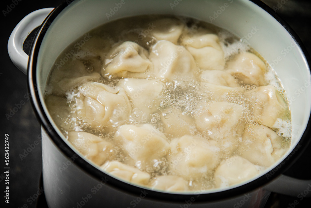 Dumplings are boiled in a saucepan in boiling water. Dumplings are boiled in a saucepan in boiling water.