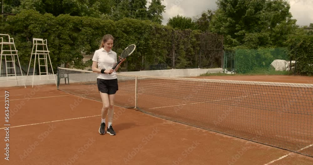 Smiling young lady standing on tennis indoor court Smiling young lady standing on tennis indoor court
