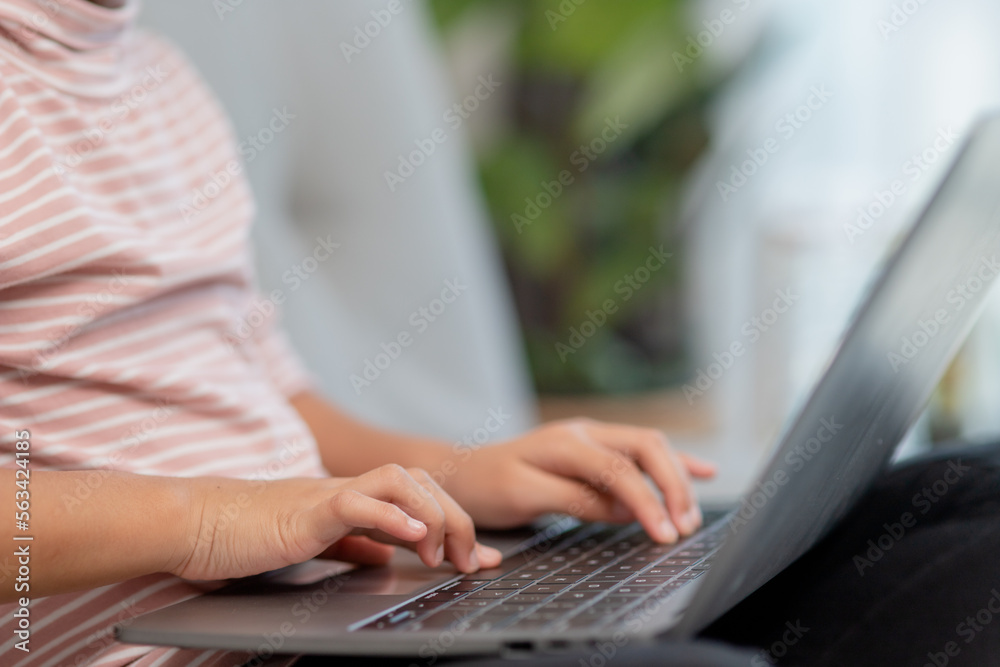 Asian Little school kid girl use laptop computer sitting on sofa alone at home. Child learning reading online social media content, play education lessons game chatting with friends. Asian Little school kid girl use laptop computer sitting on sofa alone at home. Child learning reading online social media content, play education lessons game chatting with friends.