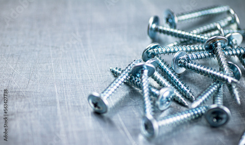 A bunch of self-tapping screws on the table. 