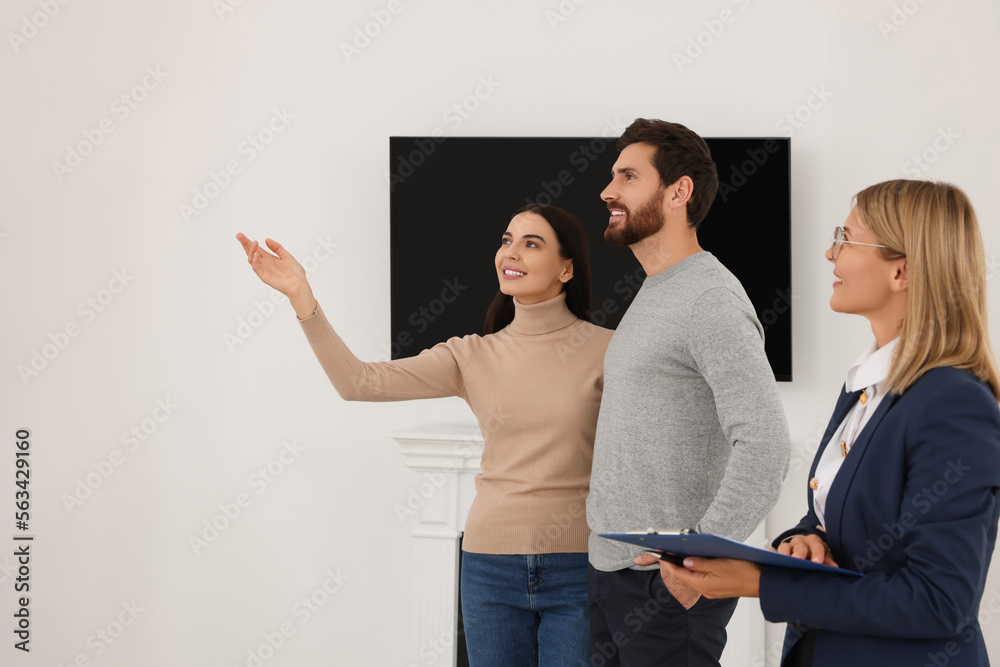 Fototapeta premium Real estate agent showing new apartment to couple