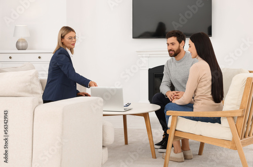Real estate agent consulting couple in new apartment