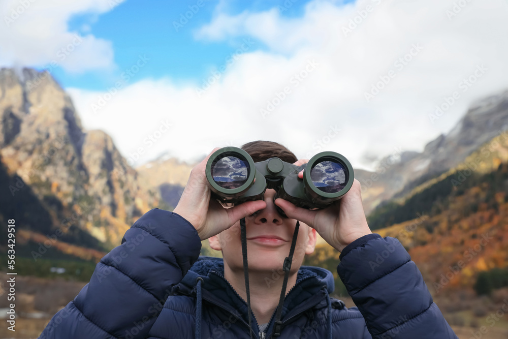 Boy looking through binoculars in beautiful mountains, closeup Boy looking through binoculars in beautiful mountains, closeup
