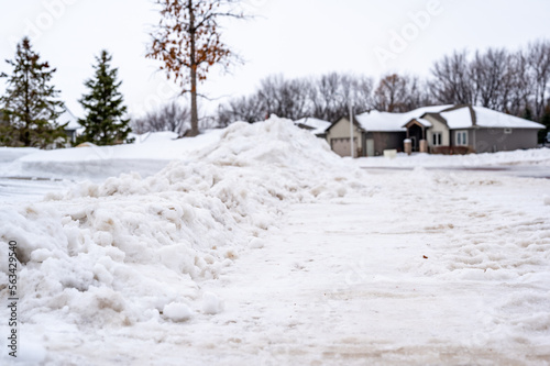 Snowbank at the end of a driveway left after city snowplows cleared a street. © Lost_in_the_Midwest