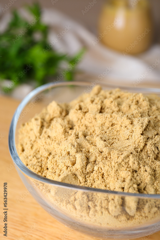 Bowl of aromatic mustard powder on table, closeup Bowl of aromatic mustard powder on table, closeup