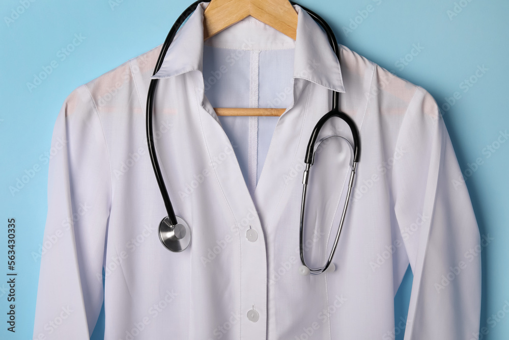 Medical uniform and stethoscope on light blue background Medical uniform and stethoscope on light blue background