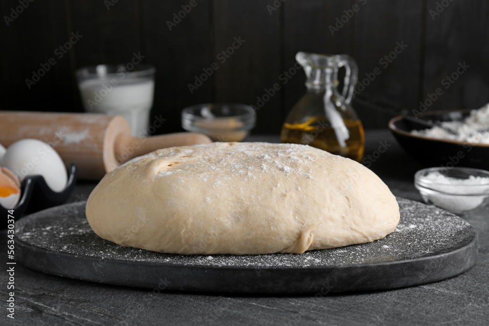 Fresh yeast dough with flour on black table Fresh yeast dough with flour on black table