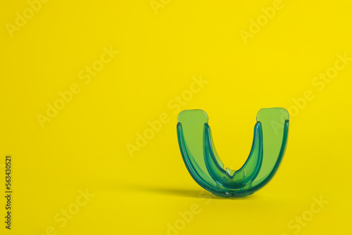 Fotografia Transparent dental mouth guard on yellow background, space for text