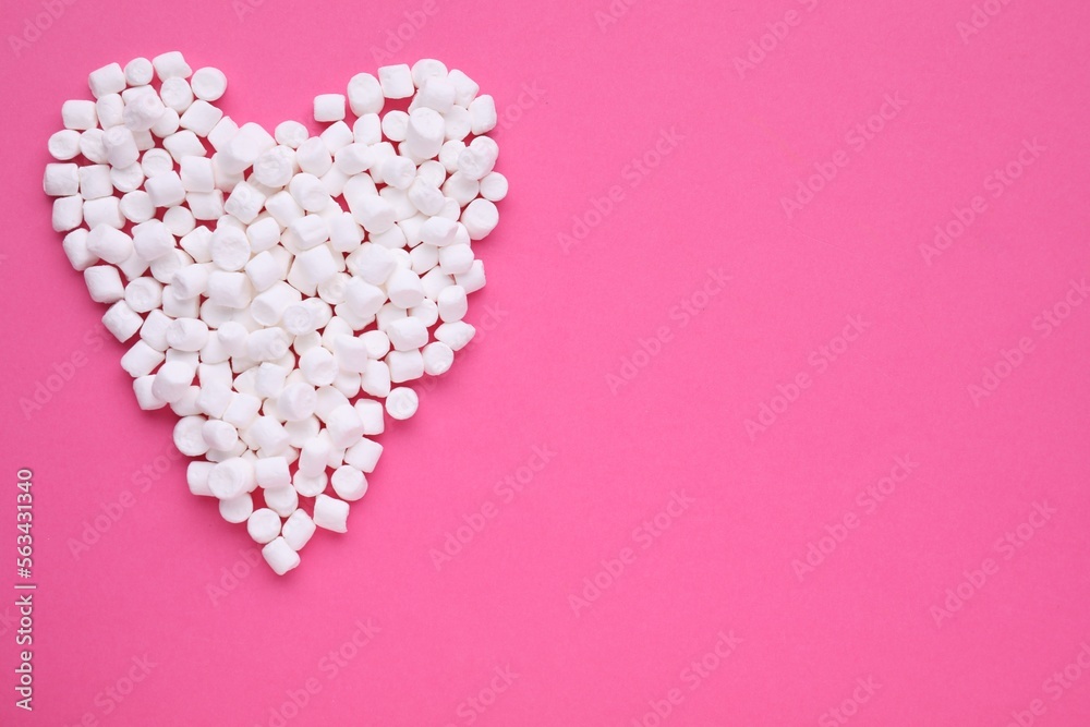 Heart made of delicious marshmallows on pink background, flat lay. Space for text