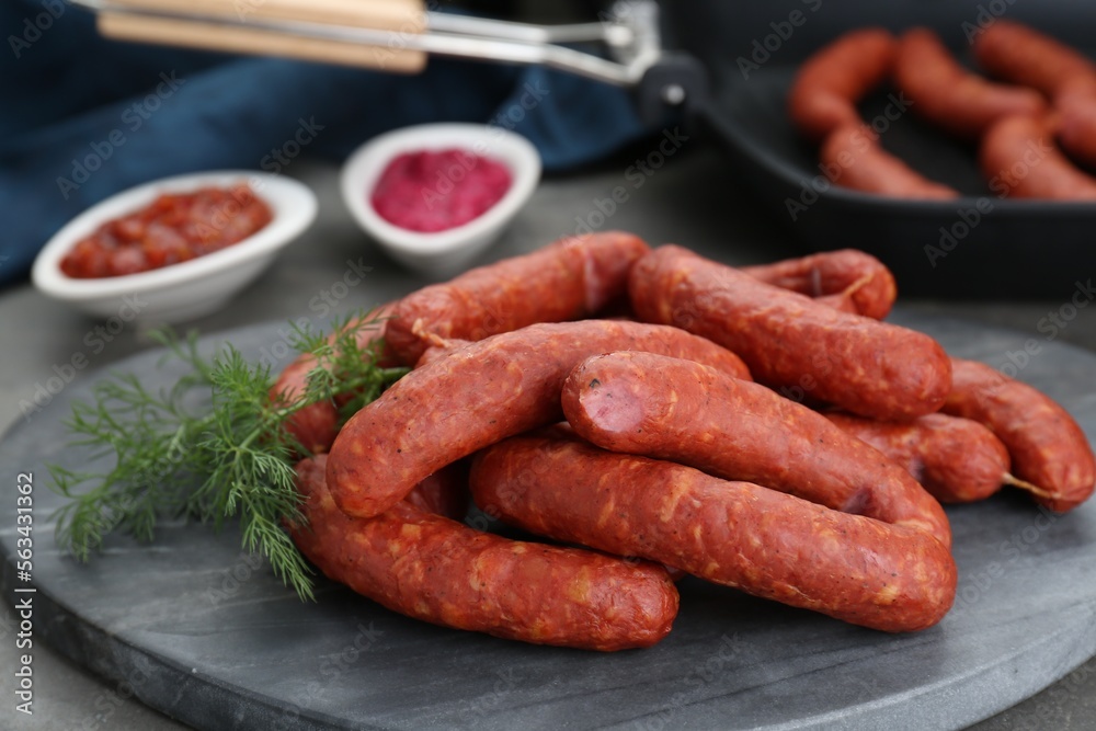 Delicious sausages and dill on grey table Delicious sausages and dill on grey table