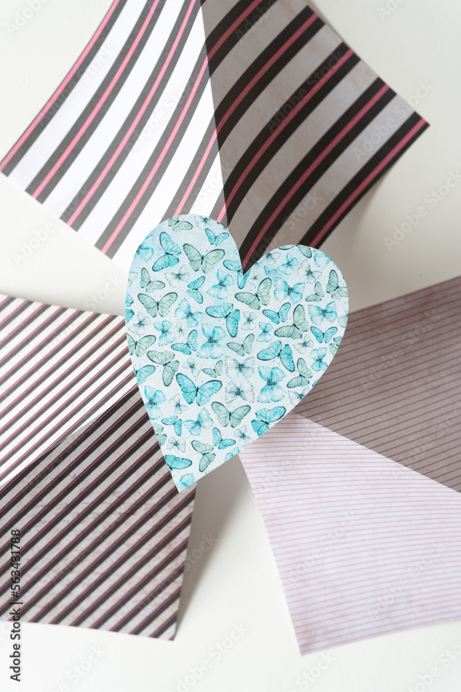 Obraz premium simple blue heart with butterflies on folded scrapbook paper sheets