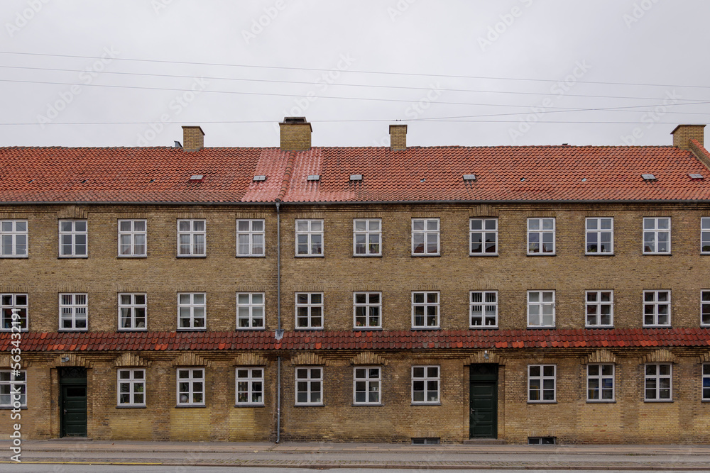 Fototapeta premium Exterior front elevation street view of typical old brick apartment in Copenhagen, Denmark. 
